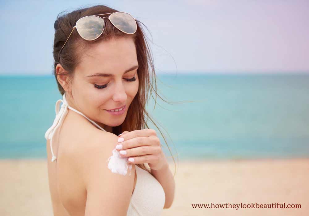 Woman wearing sunscreen on beach